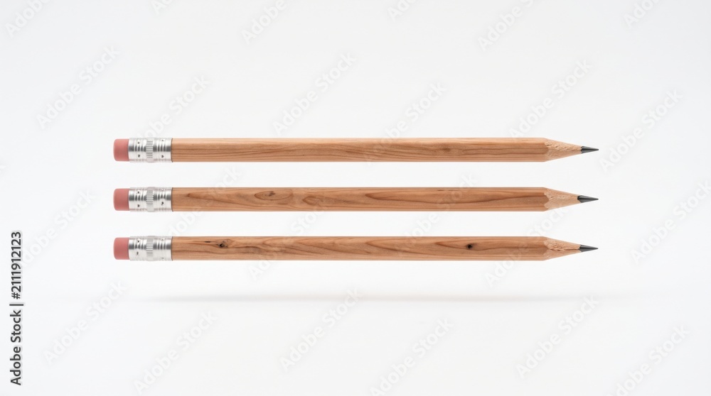 Obraz premium Three wooden pencils arranged horizontally on white background ideal for education, business branding, and creative office supplies presentation