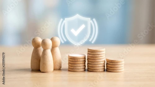 Glowing security shield icon pulsing above wooden coins and family figures for financial insurance concept.