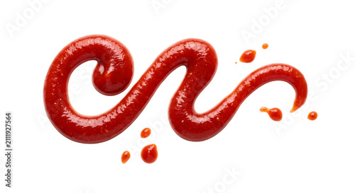 A vibrant swirl of red tomato ketchup with droplets on a clean white background