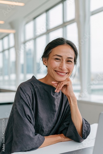 Smiling professional woman portrait in bright modern office by window for corporate profile background and business website banner