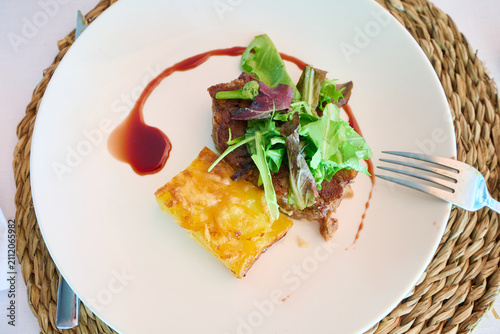 Gourmet meat dish plating with potato gratin and sauce