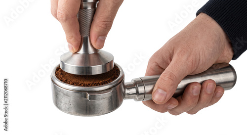 Foto Barista tamping fresh coffee grounds in a portafilter for espresso preparation