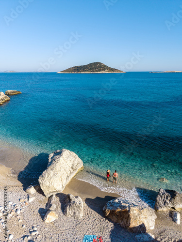 Stunning Gerenlik Beach in Kas Antalya, Turkey with couples enjoying the sunlit shore