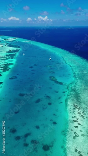 Aerial view of a tropical island, in tropical island with clear blue water and sky, with island, clear blue water, sky, from a high aerial perspective perspective, with blue, green accents.