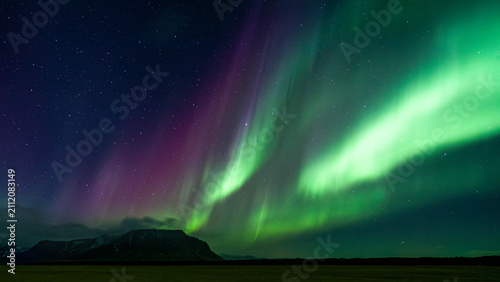 Fotografía Green Northern lights Aurora Borealis exploding in the night sky