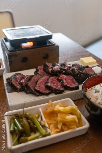 Set of Black Gyukatsu or beef cutlet served with butter. A traditional Japanese food that consists of a deep-fried beef cutlet.
