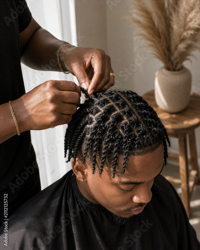 A person styling another person's hair with braids in a salon setting