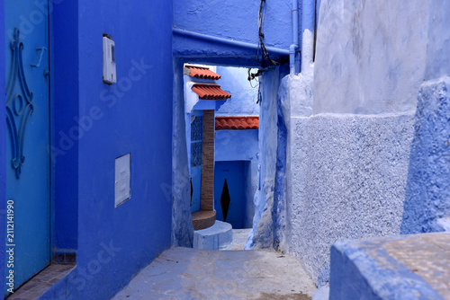 Traditional painted houses along narrow blue street in Chefchaouen Medina, Morocco