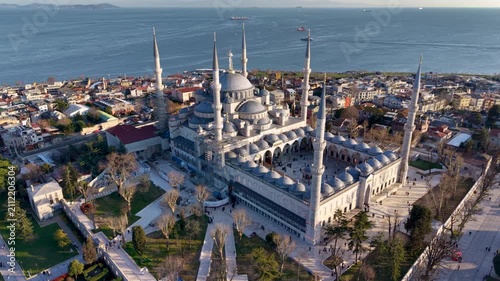 Beautiful aerial view of the iconic Blue Mosque (Sultan Ahmed Mosque) in Istanbul, Turkey, captured during golden hour. The historic Ottoman mosque dominates the skyline with its six elegant minarets 