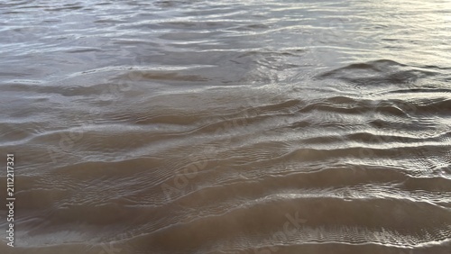Bild auf Leinwand Gentle ripples create a soothing texture on the murky water surface