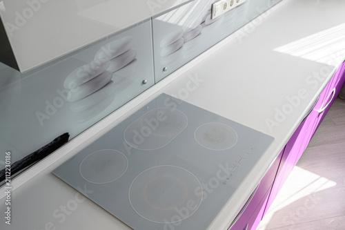 Bild auf Leinwand modern kitchen features a sleek gray glass‑ceramic four‑burner cooktop on a whit