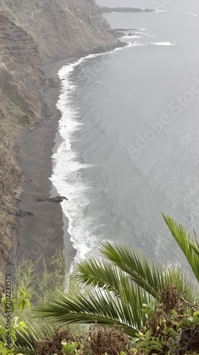 Vertical Shot capturing the Dramatic Atlantic Ocean Scenery from Mirador los 500 Escalones in Tenerife, Canary Islands. Windy Coastal Landscape with Sea, Palm Tree and Steep Cliffside Views.
