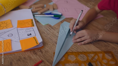 Boy, constructing a paper airplane in a cozy home setting. creative thinking in children.