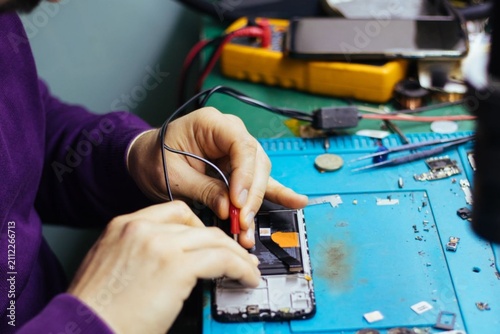 Cuadro en lienzo Hands repair phone with precision and care