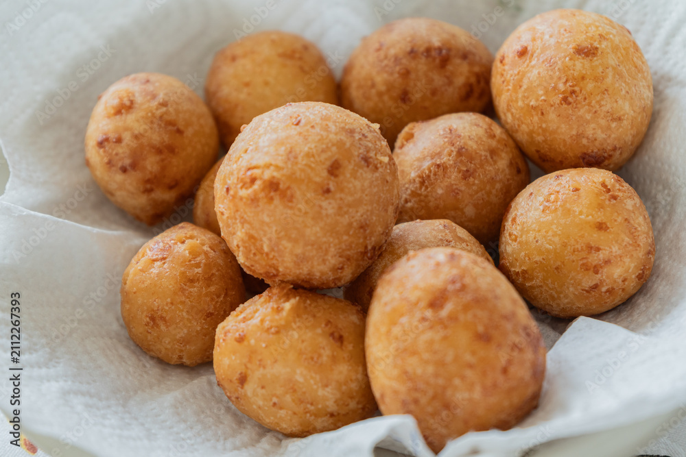 Fototapeta premium Traditional Colombian Buñuelos – Golden Fried Cheese Bread Balls Made with Cassava Flour. Served warm in a paper-lined basket, these crispy-on-the-outside, soft-on-the-inside pastries 