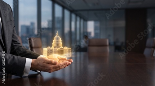 Business executive holding glowing digital government building, public private partnership and corporate subsidy concept