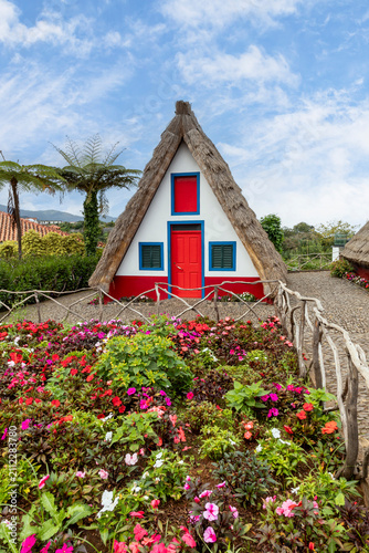 traditional colourful triangular thatched cottage and garden at santana in madeira
