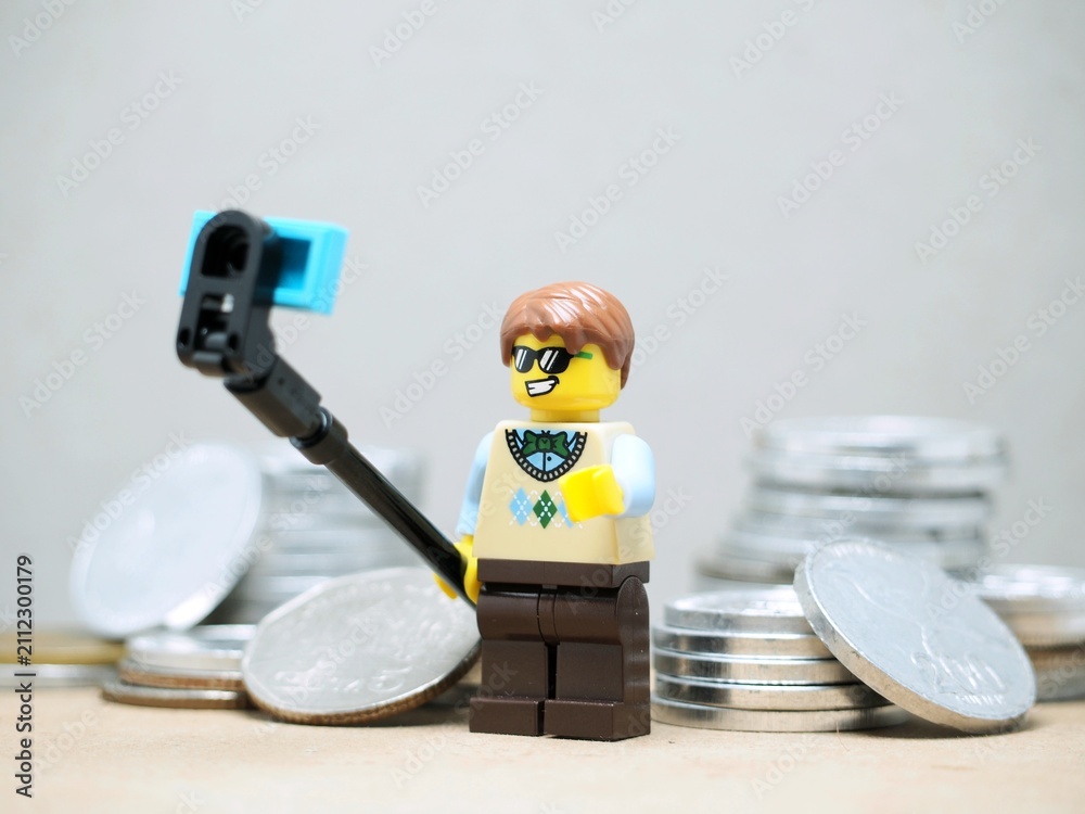 Fototapeta premium Indonesia - May 9, 2023 : Mini toy of action figure at table with blurred background. Selfie with money conceptual design.