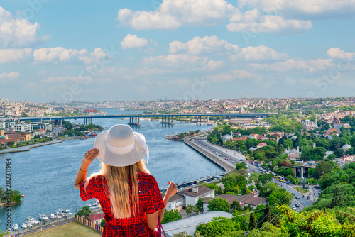 Back view of female tourist wearing sun hat looking at Golden Horn view from Pierre Loti Hill in İstanbul, Turkey