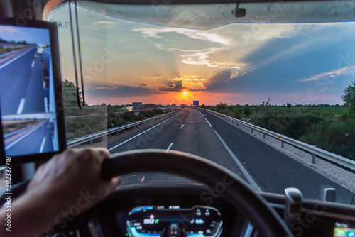 Driving a truck on an open highway during a golden sunset from the driver's perspective
