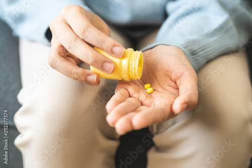Fotografía Sick asian young woman, girl holding tablet pill on hand pour from medication bottle, painkiller for allergy medicine, sleep pills or ache pain, stress for treatment, take drug