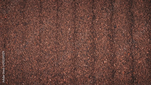 Close-up of a textured, reddish-brown surface resembling granite or rusted metal.