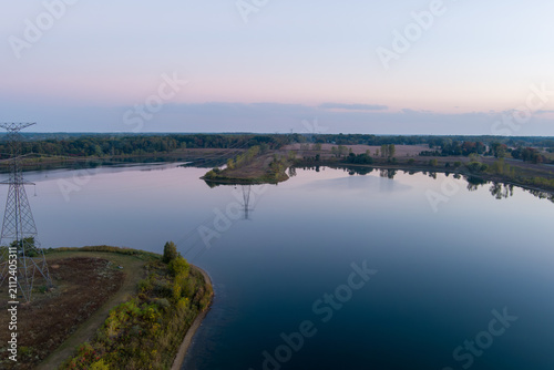 Power lines reflecting in calm Crandell lake water at sunrise