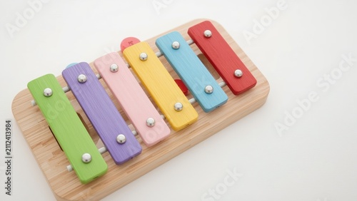 Colorful wooden xylophone on a wooden base with keys in green, purple, pink, yellow, blue, and red.