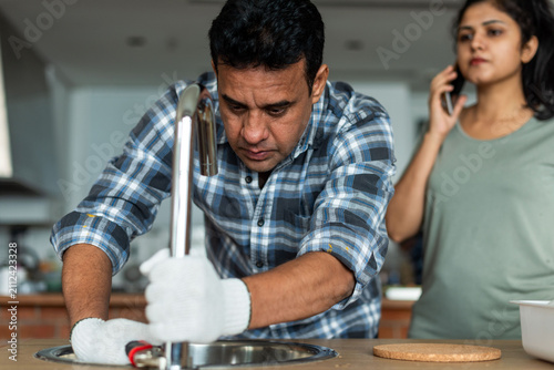 Photography Plumber fixing kitchen sink photo