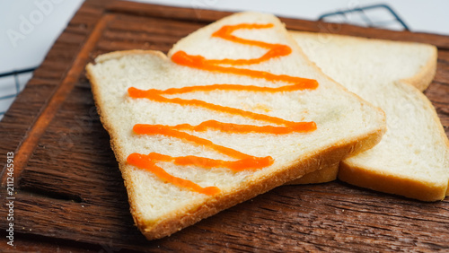 A slice of bread with a red stripe of ketchup on it