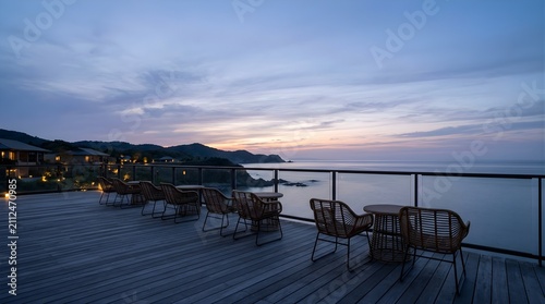 Empty wicker chairs on a luxury oceanfront deck at sunset twilight