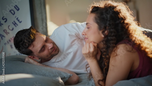 Foto Loving couple lying bed sunny morning