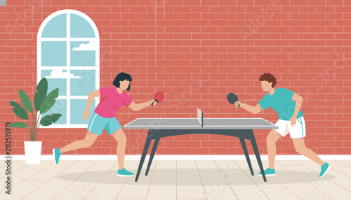 Active man and woman playing a fast-paced game of table tennis in an indoor room with a red brick wall.