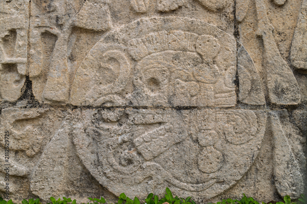 Obraz premium Close up of the stone relief carving depicting a skull inside a ball representing sacrifice trophy on the Great Ball Court wall in Chichen Itza, Mexico
