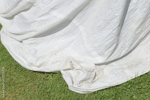 white tarpaulin material outdoors on the grass