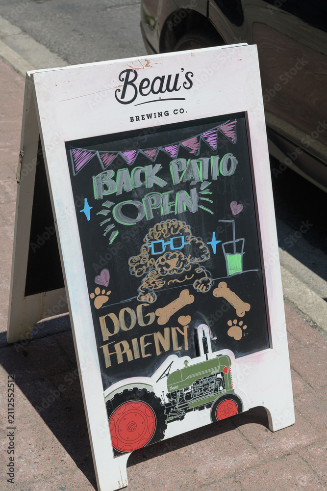 Fototapeta premium sidewalk a-frame chalkboard sign with brand marketing (Beau's Brewing Co) on Kingston Rd, Scarborough, Toronto