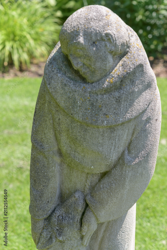 Fototapeta premium defocused view of St Francis and The Wolf by Thomas Bowie - sculpted 1956 from Indiana limestone, Guild Park and Gardens, Scarborough, Toronto