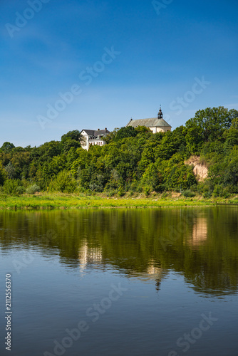 фотографія A view of the Bug River with a steep hill on which Drohiczyn is situated