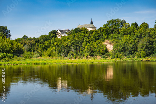 Obraz na plátně A view of the Bug River with a steep hill on which Drohiczyn is situated