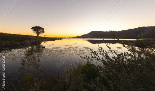 dusk falling on placid pond, Klein mountains in background, Stanford, South Africa