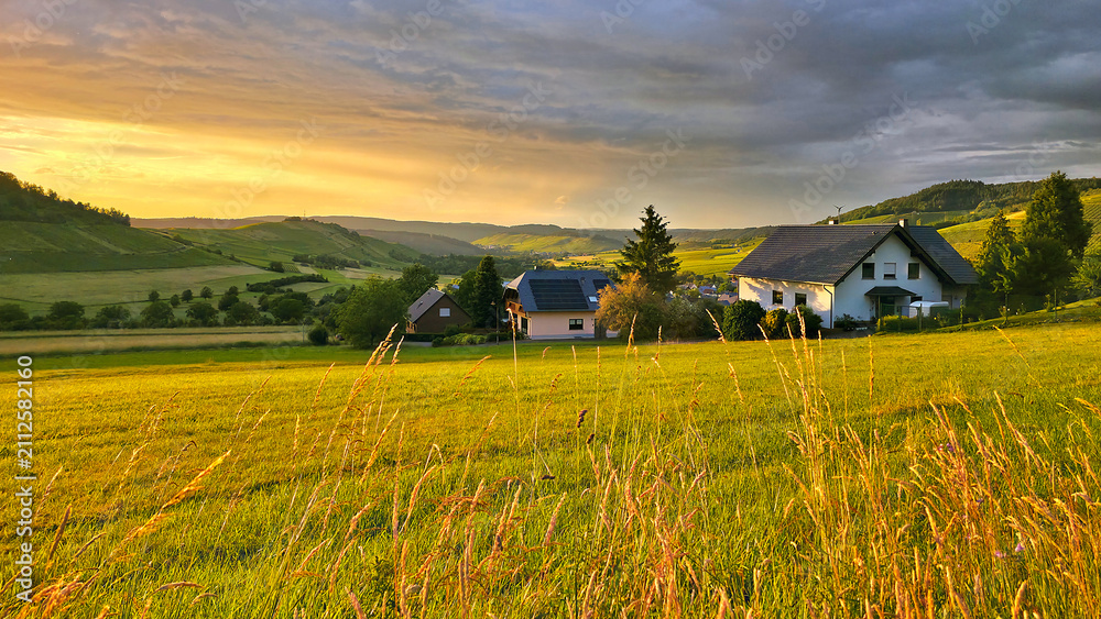 Obraz premium Sunset view over the beautiful rolling fields and vineyards of the Mosel region of Germany during summer