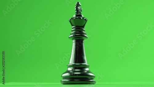 A black chess king, symbolizing leadership and strategy in business, set against a green 4K background.