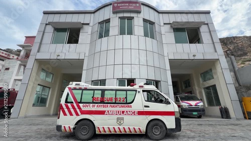 An official Rescue 1122 ambulance parked directly behind a departmental office building in Pakistan, prepared to deploy for emergency medical responses and highlighting the importance of rapid rescue 