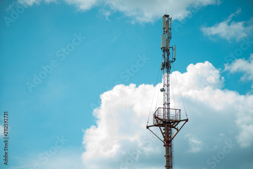 Cell Tower Against a Blue Sky with Fluffy Clouds