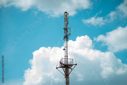 Cell Tower Against a Blue Sky with Fluffy Clouds
