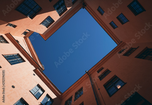 Low angle view of an inner courtyard framed by peach buildings
