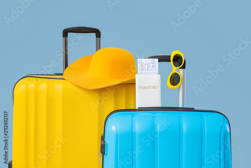 Foto Yellow and blue travel suitcases with passport, boarding pass, hat, and sunglass