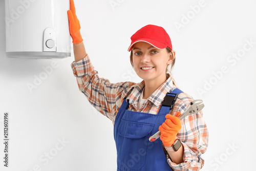 Smiling female plumber in u...