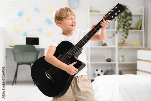 Little boy playing guitar i...