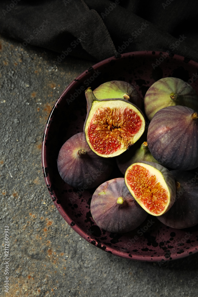 Obraz premium Bowl with fresh ripe figs on grunge background